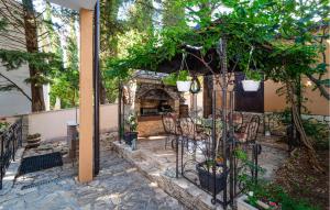 a patio with chairs and a stone fireplace at Stunning Apartment In Rovanjska in Rovanjska +19 photos