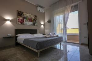 1 dormitorio con cama y ventana grande en B&B 3 Vele, en Porto Cesareo