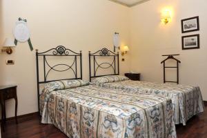 a bedroom with a bed and a clock on the wall at Villa Felcaro - Relais, Lodge & Restaurant in Cormòns