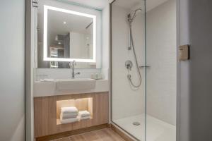 a bathroom with a sink and a shower at The Jangle Hotel - Paris - Charles de Gaulle - Airport in Le Mesnil-Amelot