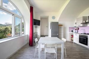 a kitchen with a white table and chairs in it at Appartamento con vista esclusiva sul Golfo d'Ischia in Ischia