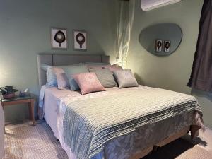 a bedroom with a bed with pillows on it at La Casa de Due in Serra Negra