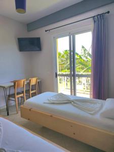 een slaapkamer met een bed, een tafel en een raam bij Apartments Vista Mar in Orikum