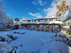 a house covered in snow in front at Bungalows Luz del sur in San Carlos de Bariloche