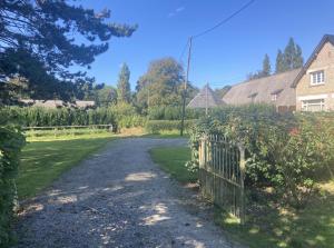 una entrada que conduce a una casa con una valla en La Canuche Appartement avec jardin, en Pleine-Sève 3 fotos más