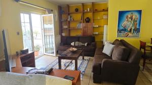 a living room with a couch and a table at Catherine's Beachfront Apartment by Optimum Link in Paralia Katerinis