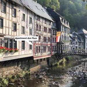 un pont sur une rivière dans une ville avec des bâtiments dans l'établissement Apartment Am Fluss im Haus An der Rur, à Monschau