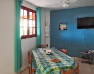 ブイヤントにあるAppartement d'une chambre avec vue sur la mer terrasse amenagee et wifi a Bouillante a 4 km de la plageの青い壁のダイニングルーム(テーブル付)