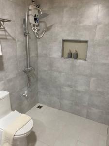baño con ducha, aseo y ventana en White Sand Inn en Maamigili
