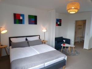 a bedroom with a large bed and a blue chair at City-Flair mit Domblick! in Cologne