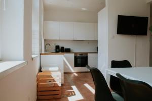 a kitchen with white cabinets and a table and chairs at Arbio Grünheide Monteurzimmer Parking included in Waldeck