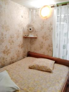 een kleine slaapkamer met een bed met een kussen erop bij Studio avec jardin et wifi a La Possession in La Possession