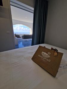 a bag on a bed with a view of the ocean at Villaggio Marco Polo in Santa Domenica