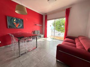 sala de estar con paredes rojas y sofá rojo en Agi Macià Centro, en Roses