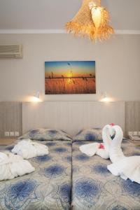 um quarto com dois cisnes sentados numa cama em Hotel Tigaki's Star em Tigaki