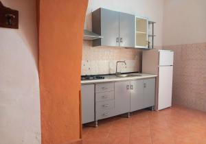 a small kitchen with a sink and a refrigerator at La Locanda in Marsala
