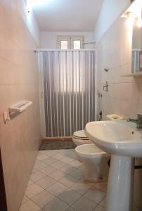 a bathroom with a toilet and a sink and a shower at La Locanda in Marsala +5 photos