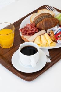 a tray with a plate of food and a cup of coffee at Hotel Tigaki's Star in Tigaki