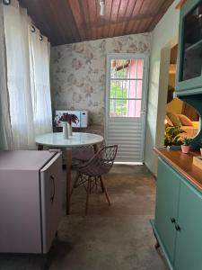 a kitchen with a table and a table and a window at La Casa de Due in Serra Negra