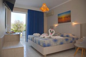a bedroom with two swans on a bed at Hotel Tigaki's Star in Tigaki