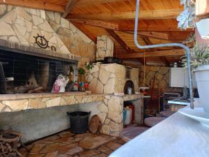 a kitchen with a stone fireplace in a house at Jack's Home Maisonette in Áno Kamárion