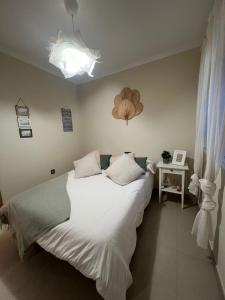 sypialnia z łóżkiem z białymi prześcieradłami i poduszkami w obiekcie Centro-Torre del mar - HOME RENT MALAGA w mieście Torre del Mar