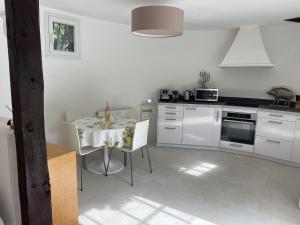 a kitchen with a table and a kitchen with white appliances at Luxurious Provencal cottage with private Pool, Terrace & Garden in Vence