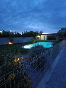a backyard with a swimming pool at night at Location villa avec piscine proche de la mer in Sauvian
