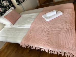 Una cama con una manta rosa encima. en Media Luna Guesthouse, en Seyðisfjörður