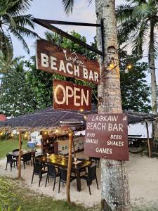 una señal para un bar de playa con mesa y sillas en Lagkaw Siargao Villas, en General Luna