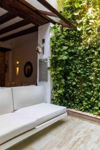 eine weiße Couch vor einer grünen Wand in der Unterkunft Casa Gastelbondo in Cartagena de Indias
