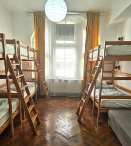 ein Zimmer mit vier Etagenbetten und einem Fenster in der Unterkunft Centrum House Hostel in Braşov