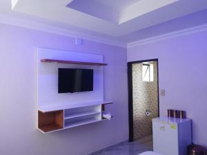 a living room with a flat screen tv on a wall at Zurich Garden Hotel in Benoni