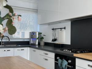 een keuken met witte kasten en een fornuis met oven bij The Camden Retreat in Londen