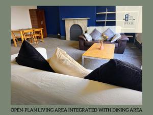 a living room with a couch with pillows on it at Lil Victorian Classic Group Home in Leeds