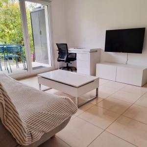 a living room with a couch and a desk and a tv at T2 Paris Disneyland Jardin Parking in Noisy-le-Grand