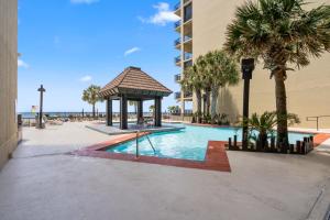 una piscina con cenador junto a un edificio en Romar House Unit 506A, en Orange Beach