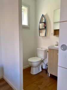 a bathroom with a toilet and a sink and a window at Chambre indépendante et paisible dans maison neuve in Mimizan