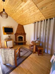 a living room with a fireplace in a house at Chalé Recanto Belo. in São Mateus