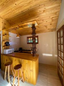 a kitchen with a counter and stools in a room at Chalé Recanto Belo. in São Mateus