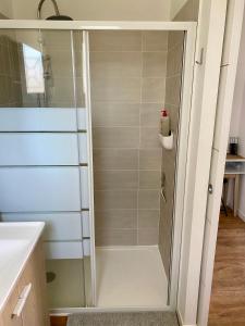 a shower with a glass door in a bathroom at Chambre indépendante et paisible dans maison neuve in Mimizan