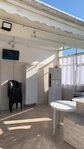 a room with a table and a chair and a refrigerator at Casa de Maria in Aparecida +30 photos
