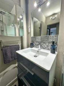a bathroom with a sink and a mirror at Charmant T2 aux portes de Paris in Aubervilliers