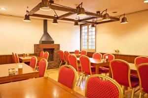a dining room with tables and chairs and a fireplace at Ageo Tobu Hotel in Ageo