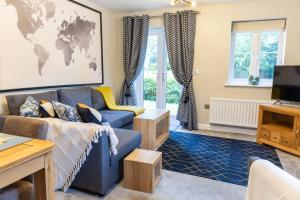 a living room with a blue couch and a world map on the wall at Luxury Apartments - MBS Lettings in Bewdley
