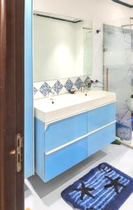 ein Badezimmer mit einem blauen Waschbecken und einem Spiegel in der Unterkunft 2 bedrooms apartement with balcony at Nouaseur in Nouaseur