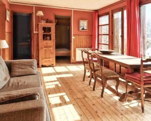 sala de estar con mesa de madera y sillas en Maison de 3 chambres avec vue sur le lac et jardin clos a Talloires Montmin, en Angon