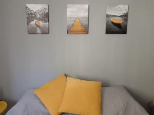 four pictures hanging on a wall above a couch at Ilgattonero in Orero