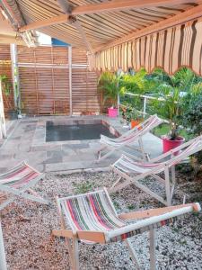 un patio con due sedie da giardino e un ombrellone di Appartement de 2 chambres avec vue sur la ville jardin amenage et wifi a Sainte Luce a 8 km de la plage a Sainte-Luce