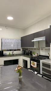 a kitchen with a table with a vase of flowers on it at Casa de Maria in Aparecida